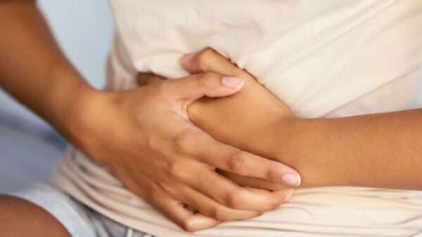 young woman holding tummy due to pain
