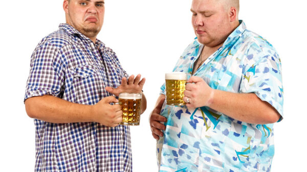 Two fat men holding a mug of beer