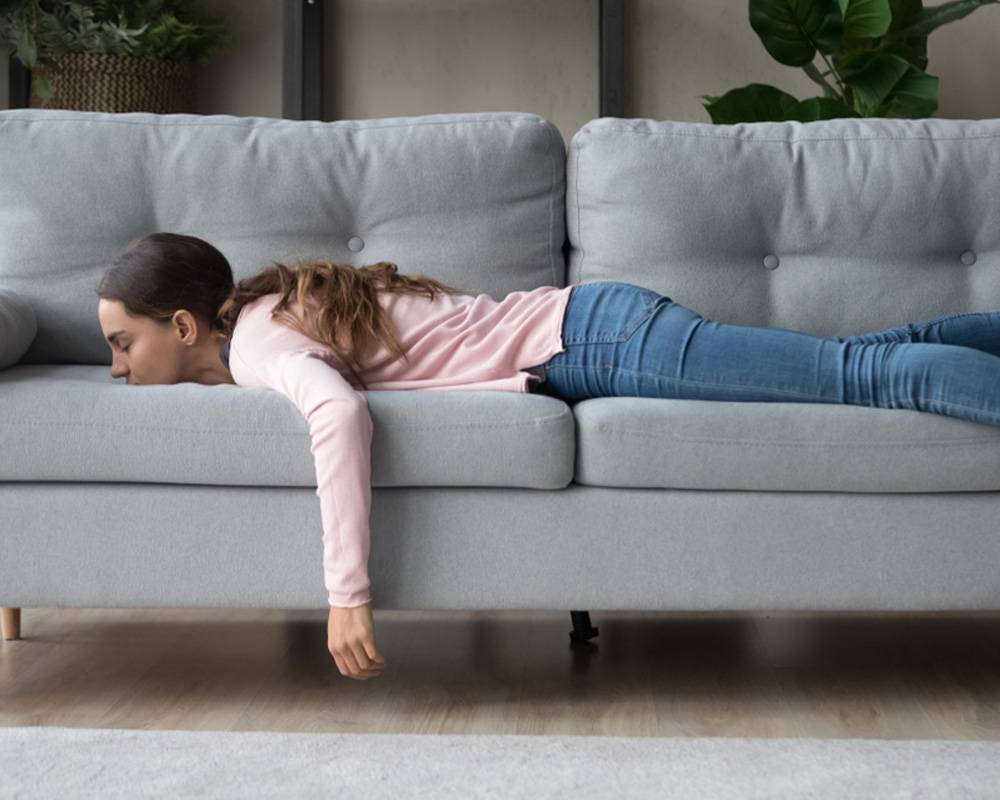 Bored woman lying down on a sofa